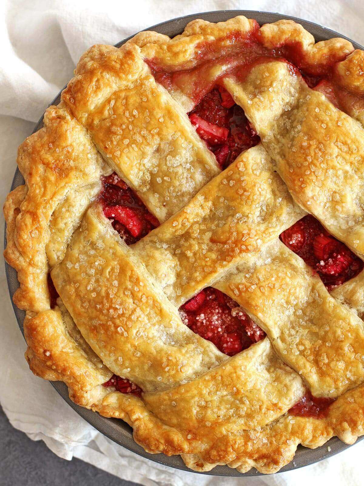 Close-up of strawberry rhubarb pie with a deeply golden, flaky crust.