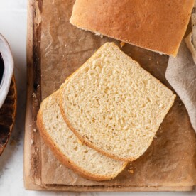 Two soft slices of sandwich bread are stacked to show the light and airy crumb.