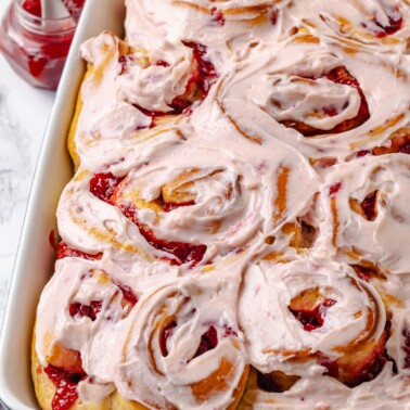 Pink strawberry rolls with glossy frosting.