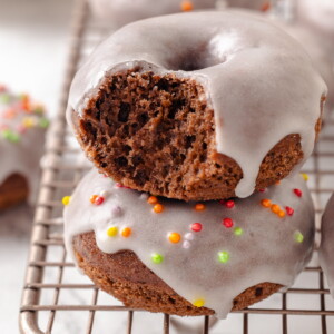 A bitten chocolate donut shows its soft, moist interior with a light glaze on the outside.