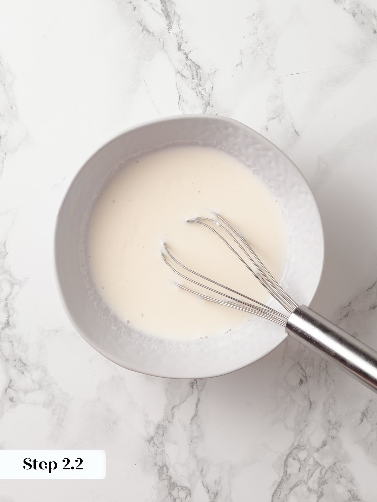 Sour cream and milk being whisked together to help create a tender, moist chocolate donut batter.