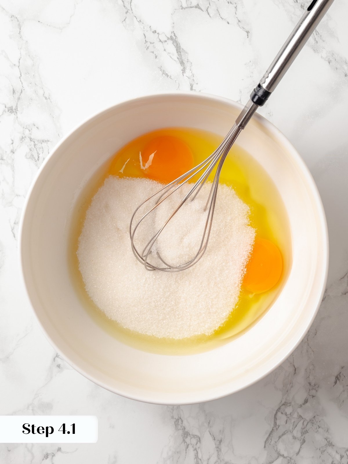 Eggs and sugar combining to start the base of moist, fluffy baked chocolate cake donuts.