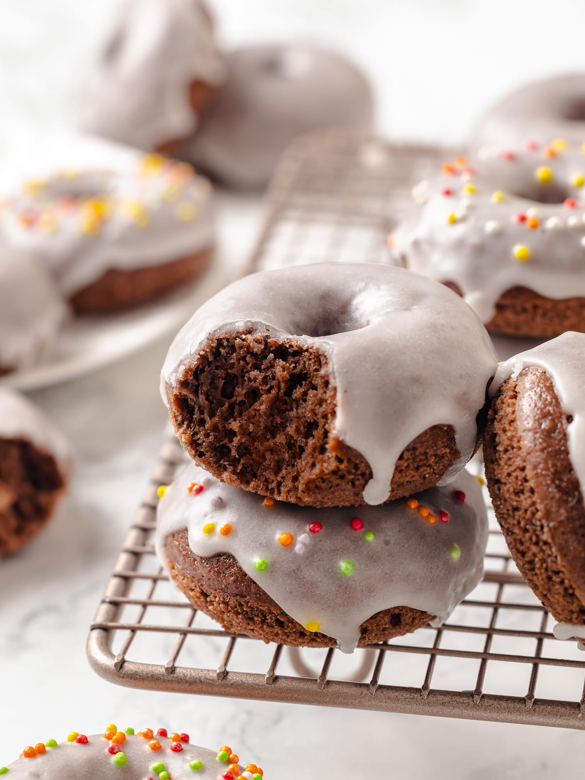 A pair of chocolate donuts stacked together, ready to be shared for a snack or breakfast.