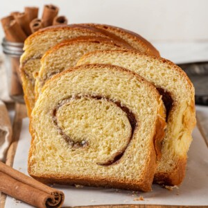 A slice of cinnamon swirl bread shows tight, beautiful layers of cinnamon sugar inside.