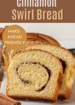 Thick slices of cinnamon swirl bread on a wooden board, ready for toasting or snacking.