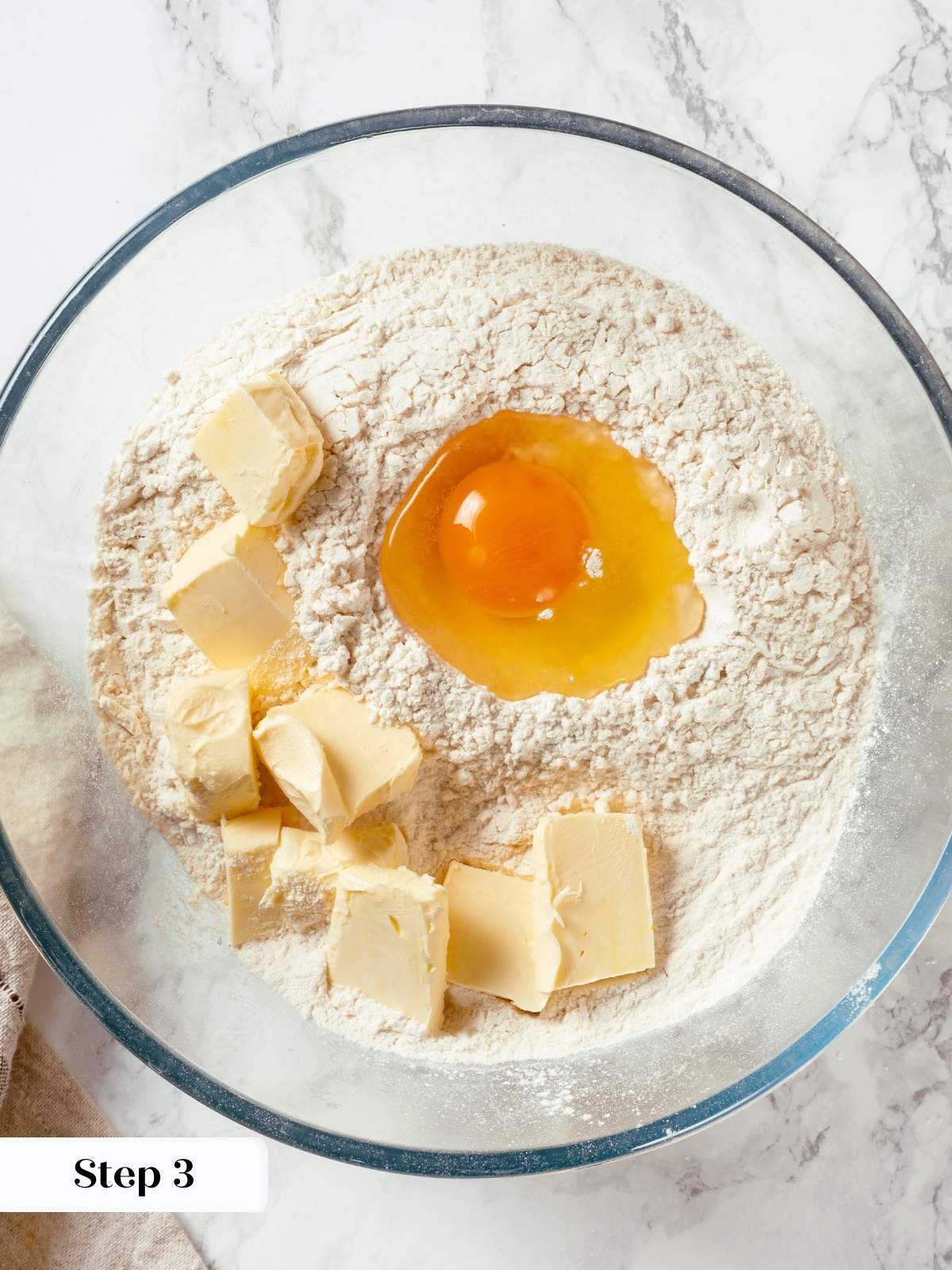 Butter, flour, egg, and salt are added on top of orange-zested sugar before mixing.