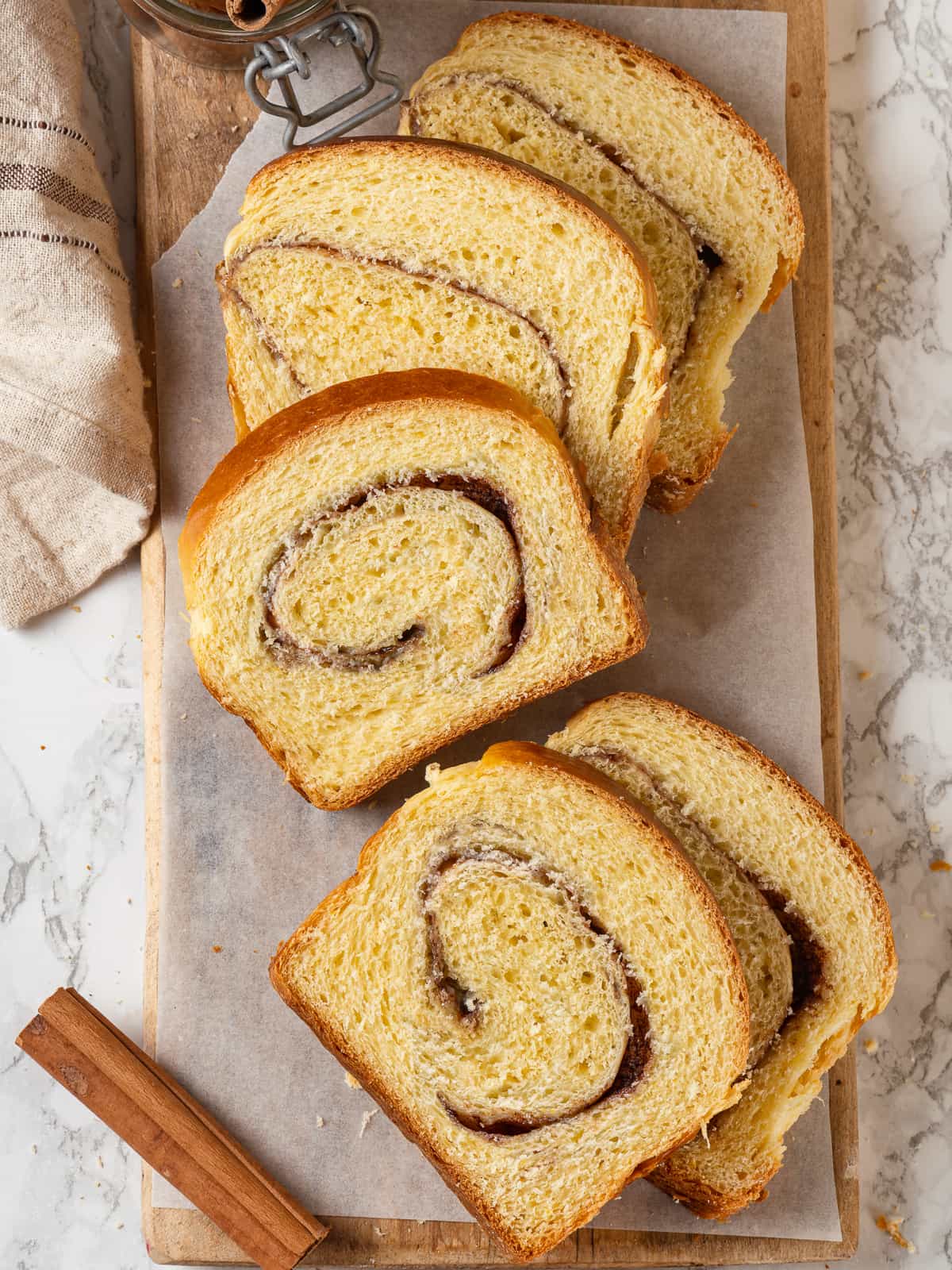 Multiple slices of cinnamon swirl bread stacked slightly, showing layers and golden crust.