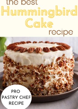 Cake with white frosting beautifully decorated with pecans on the top, and crushed pecans around the sides.