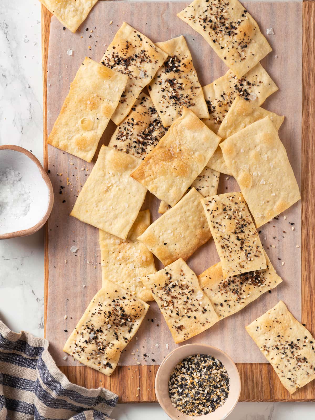 Baked crackers resting on a wooden cutting board, ready for serving or storing.
