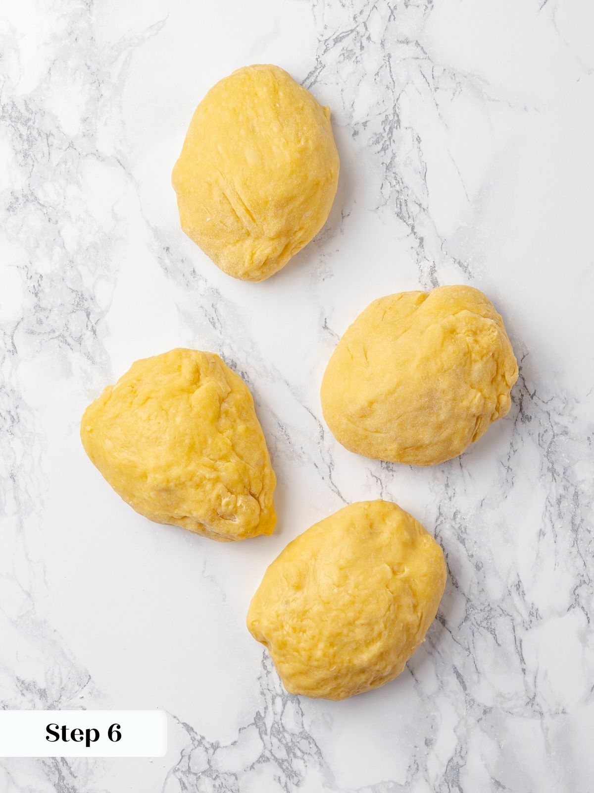 Equal-sized pieces of dough portioned for braiding, sitting on a clean work surface.