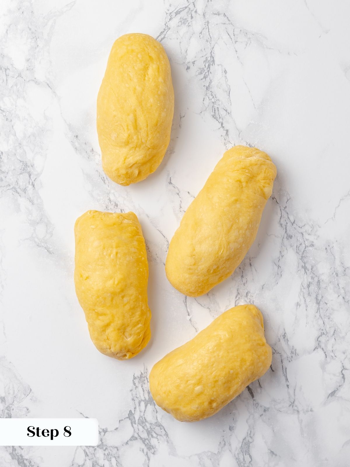 Dough formed into a log shape on the counter before rolling into ropes for braiding.