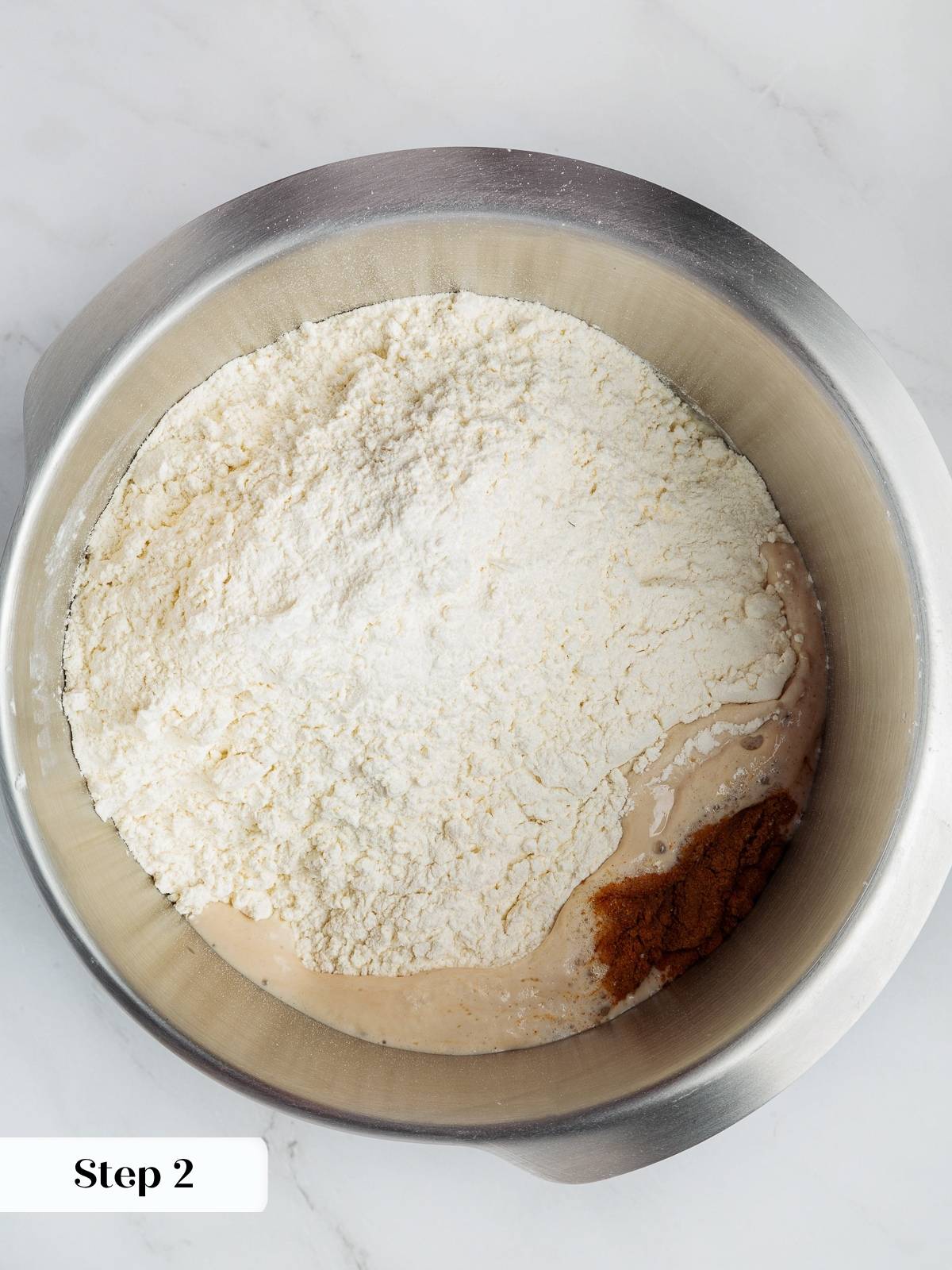Dry ingredients being added to bowl of yeast and water to begin mixing.