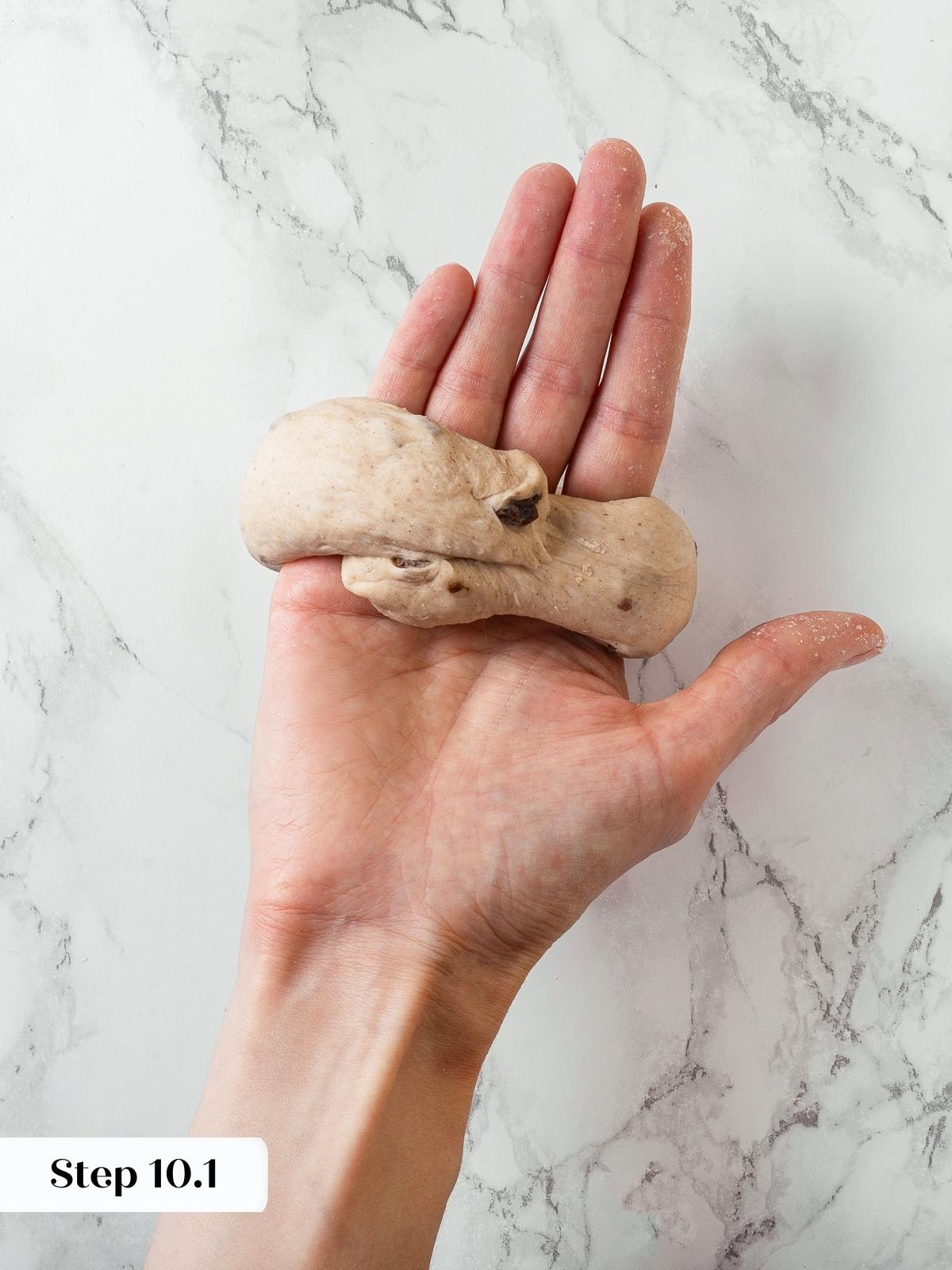 Shaping step where dough ends are joined and sealed by hand to close the loop.