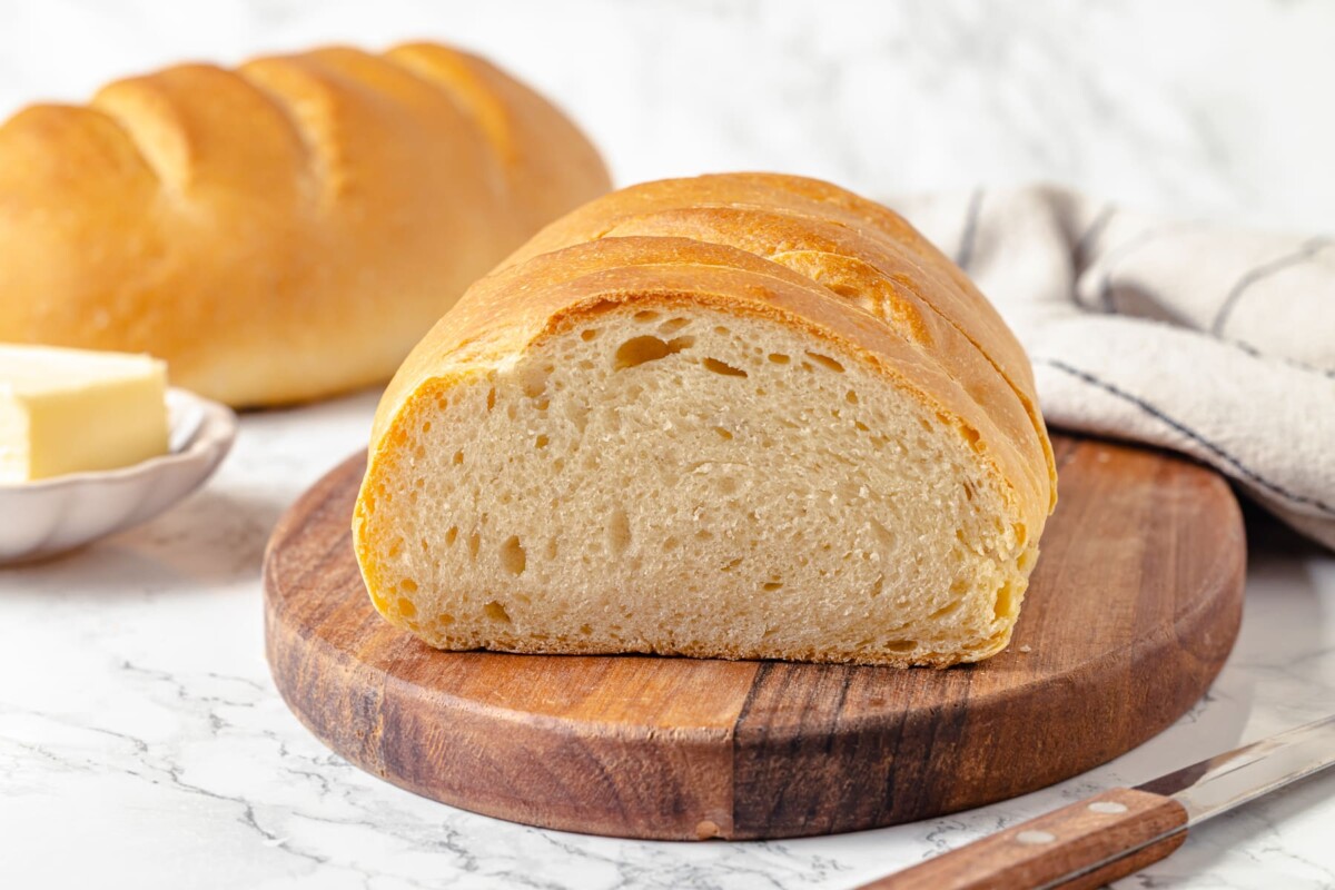The interior of the bread shows a tight, even crumb perfect for sandwiches and spreading butter.