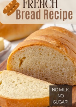Sliced loaf of French bread showing tight, fluffy crumb and tender crust with golden edges.