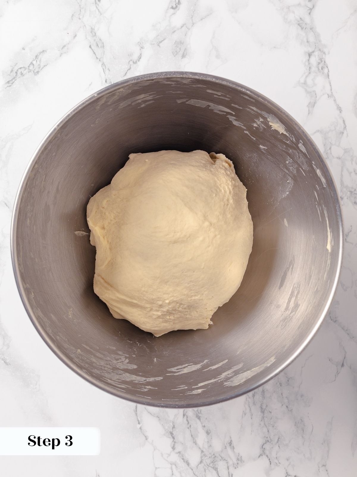 French bread dough shaped into a smooth round ball.
