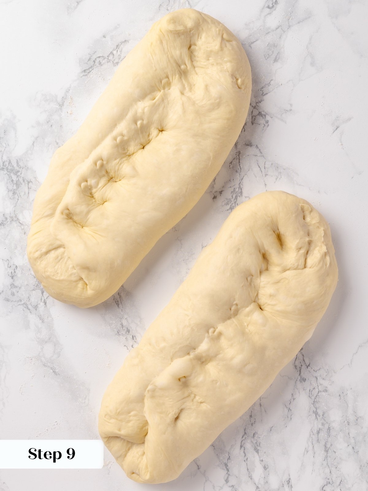 Dough being folded over itself for the first time to begin shaping the French bread.