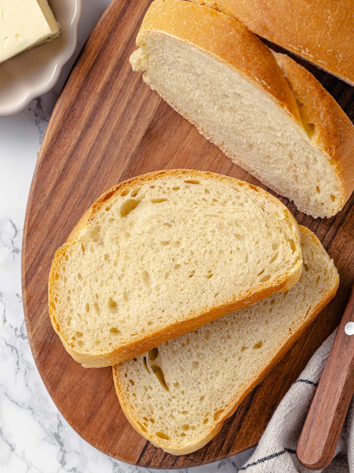 Sliced loaf of French bread showing a soft, airy interior and golden, tender crust.