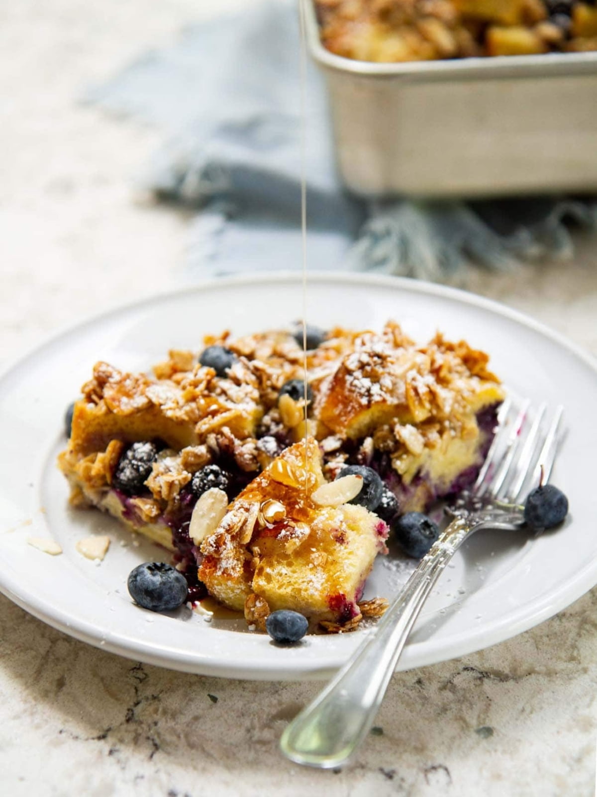 French toast casserole served warm with visible baked topping and fruit tucked into soft bread.