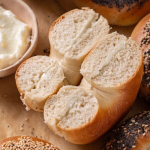 Baked sourdough bagel cut open to show the soft, chewy, well-developed crumb inside.