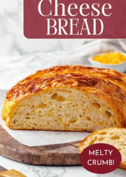Loaf of no knead cheese bread sliced open to reveal the melty interior and airy crumb.