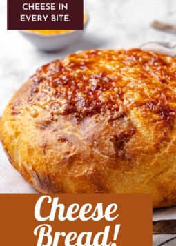 Freshly baked cheesy bread loaf on a cutting board.