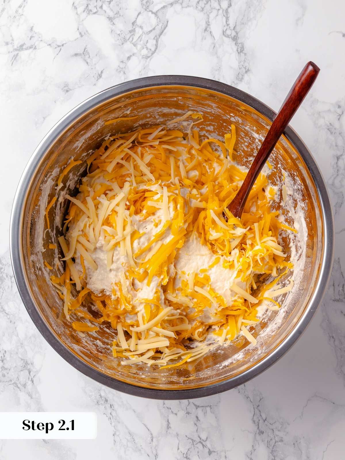 Adding cheese to unshaped dough for even melt and savory flavor throughout each slice.