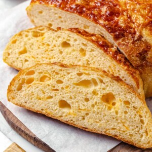 Slices of cheese bread on a plate, showing crusty edge and soft cheesy interior.