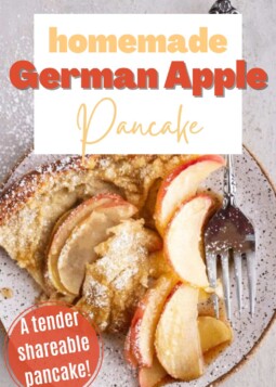 A golden, puffy German apple pancake with thinly sliced apples and topped with powdered sugar shown on a plate with a fork.