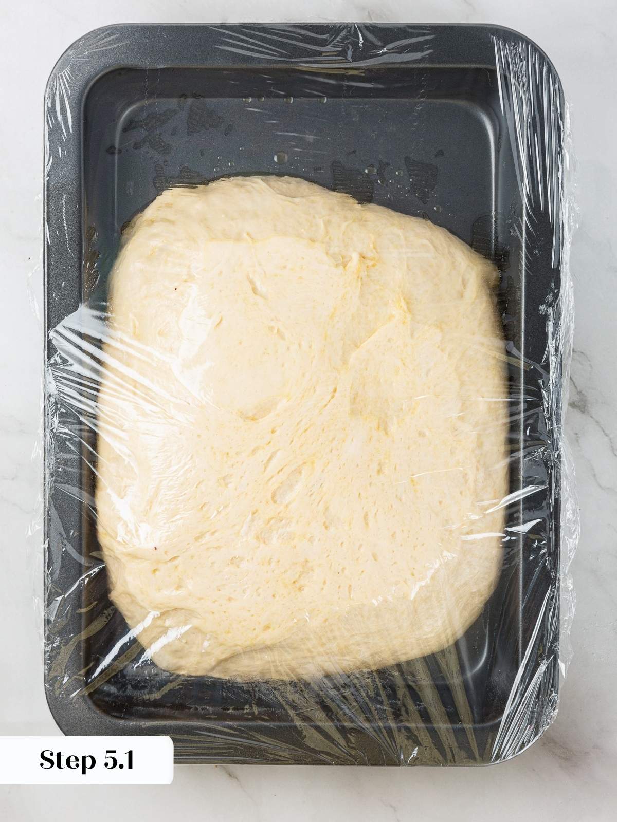 Dough resting loosely in center of pan before final stretching and shaping.