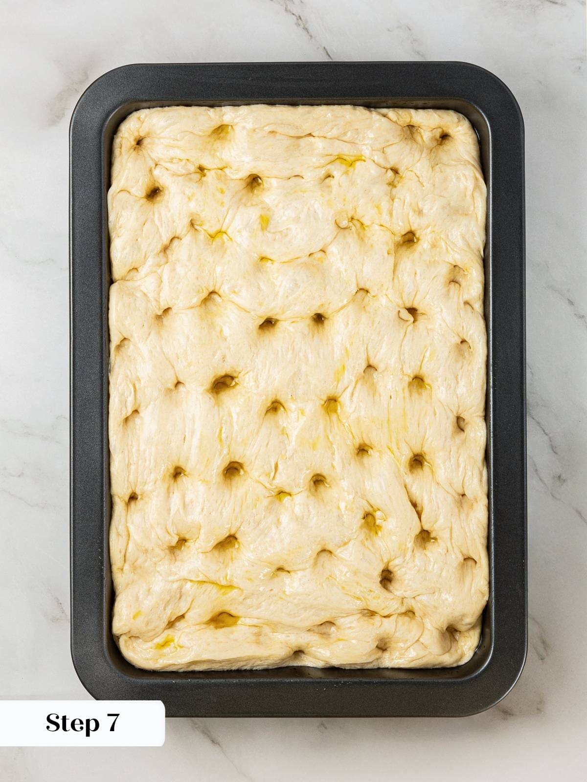 Finished dough with deep finger marks across the surface, just before baking.