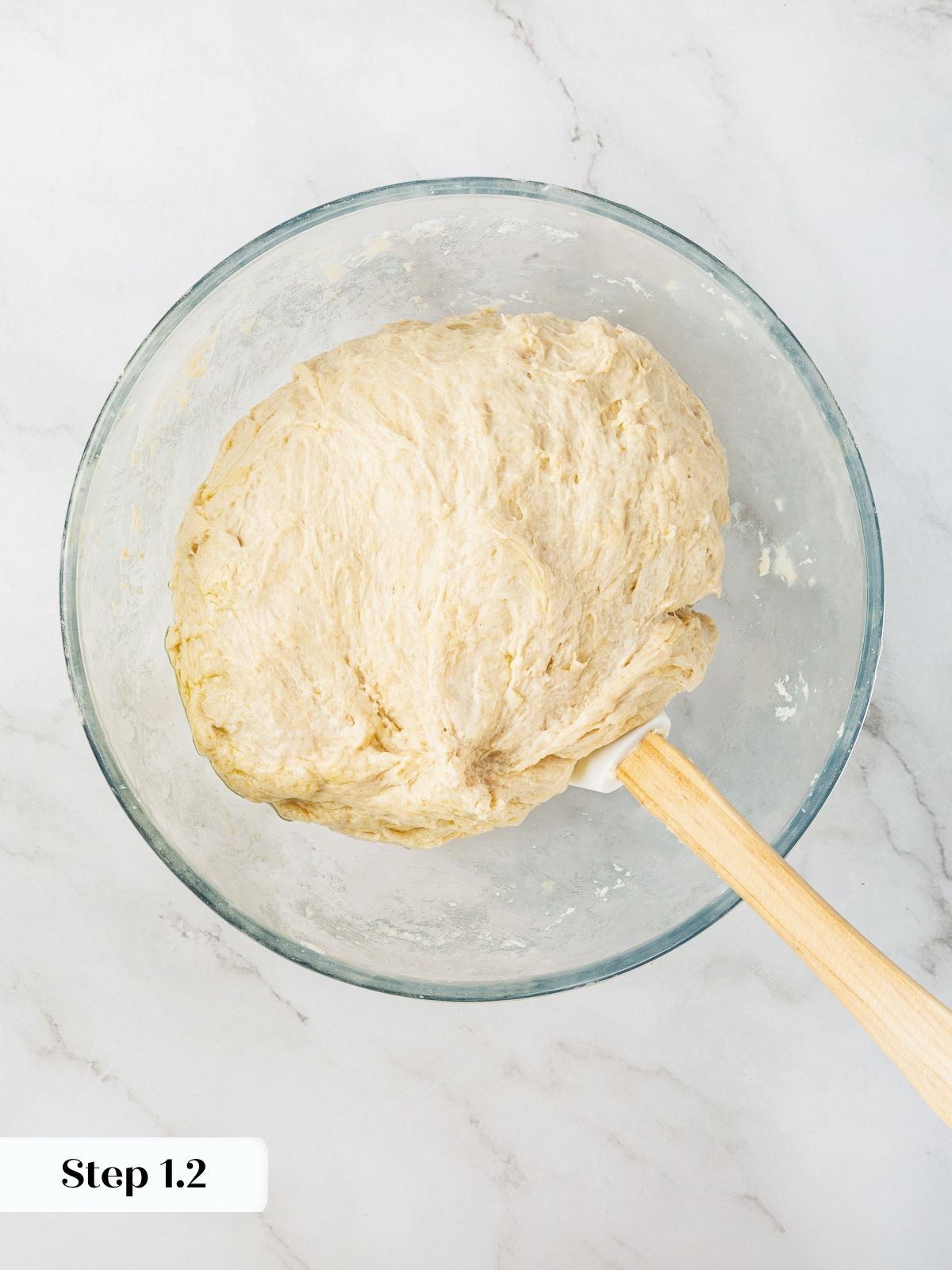 Just-mixed dough with shaggy texture resting in bowl at start of recipe.