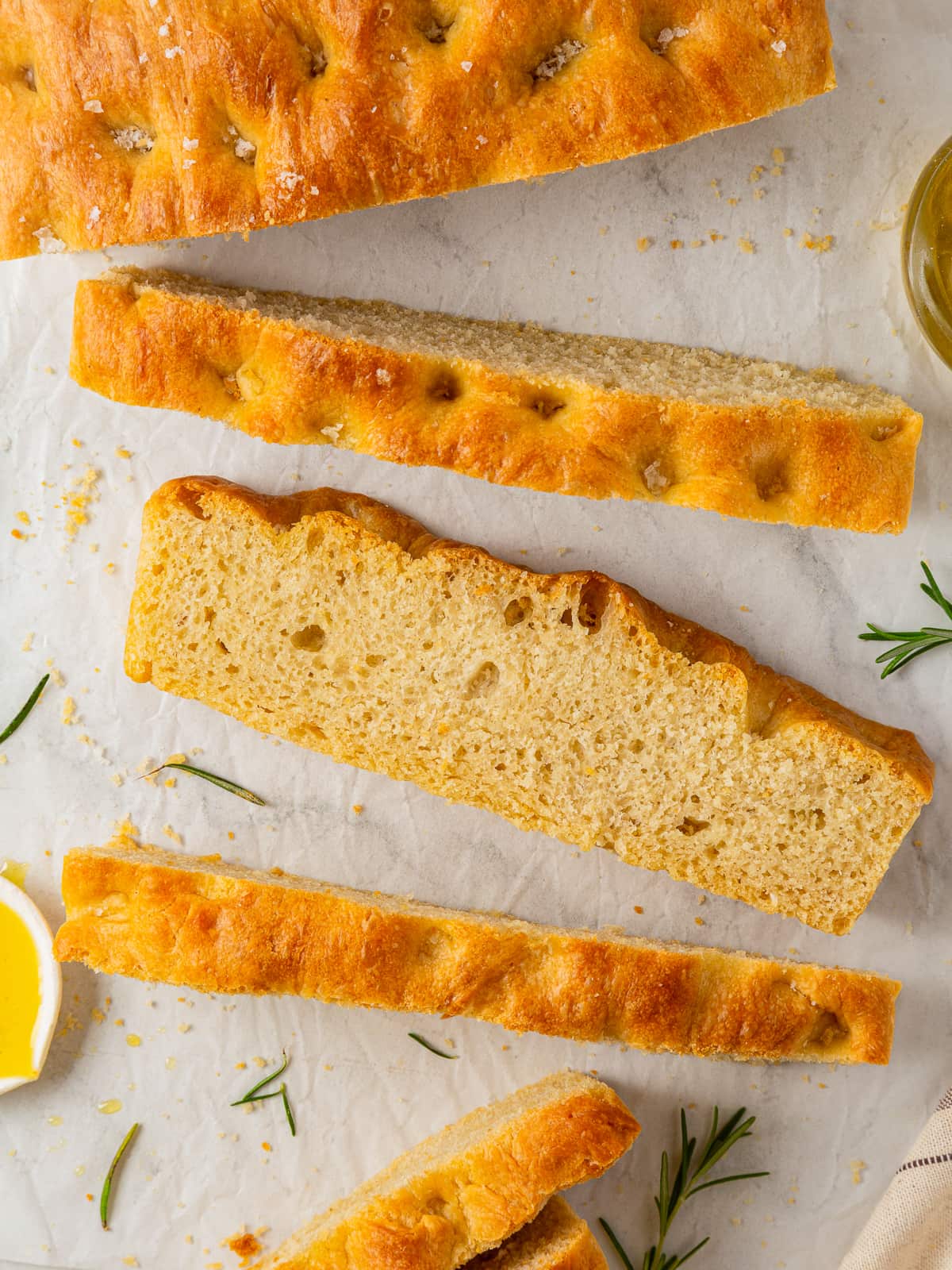 Several focaccia pieces arranged on a cutting board showing interior and crust.