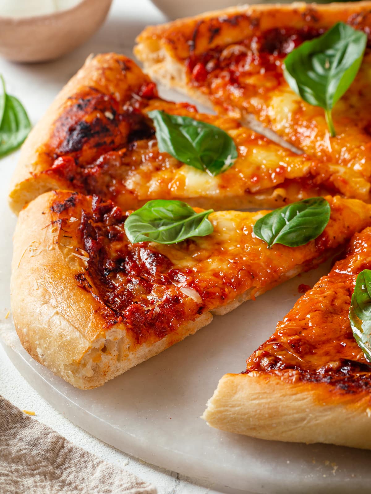 Sourdough discard pizza slice showing airy crust with golden edges.