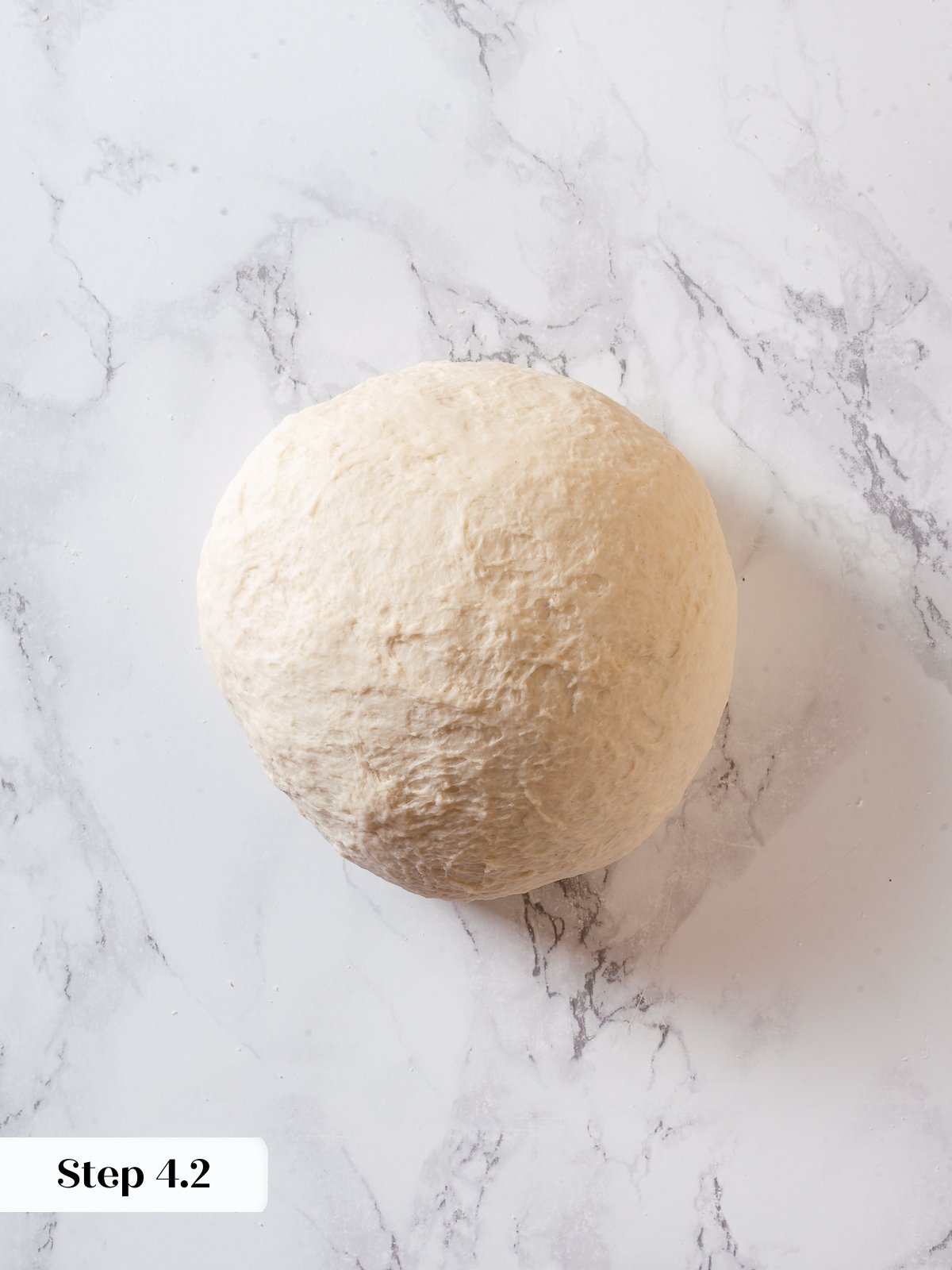 Smooth dough ball after kneading sourdough discard for homemade pizza crust.