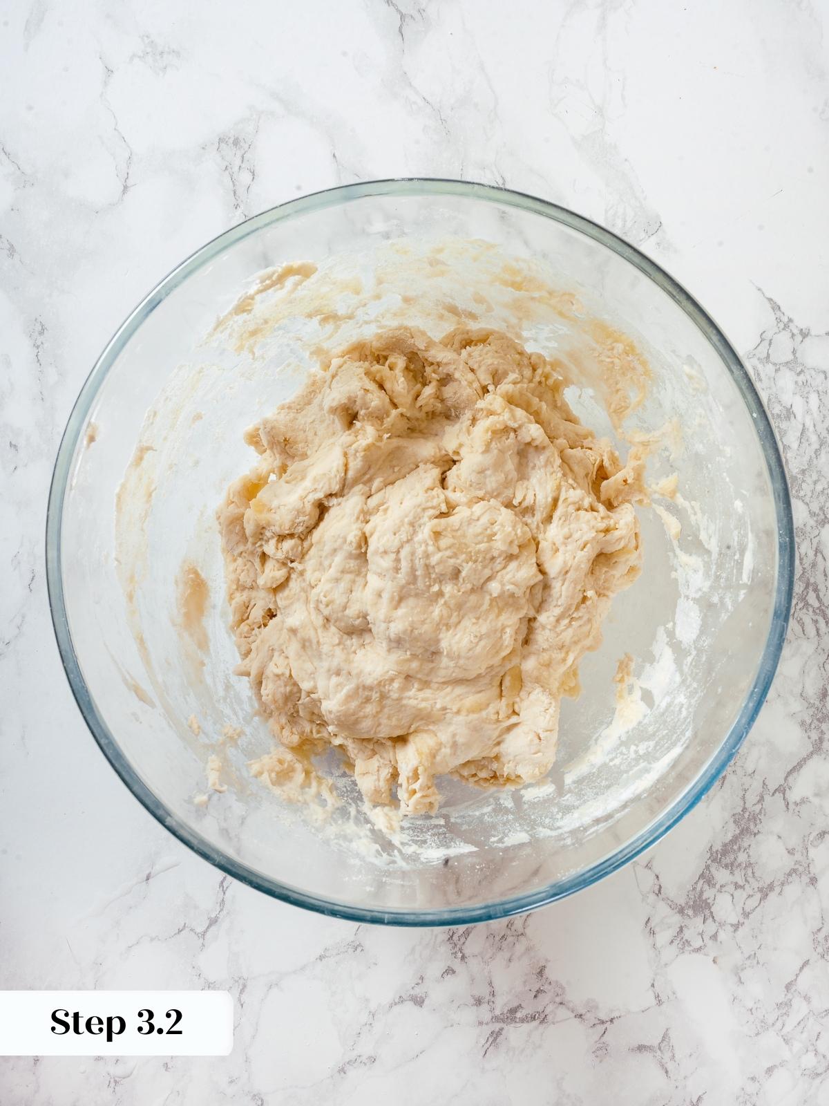 Mixed sourdough discard, flour, and yeast forming into shaggy dough for pizza crust.