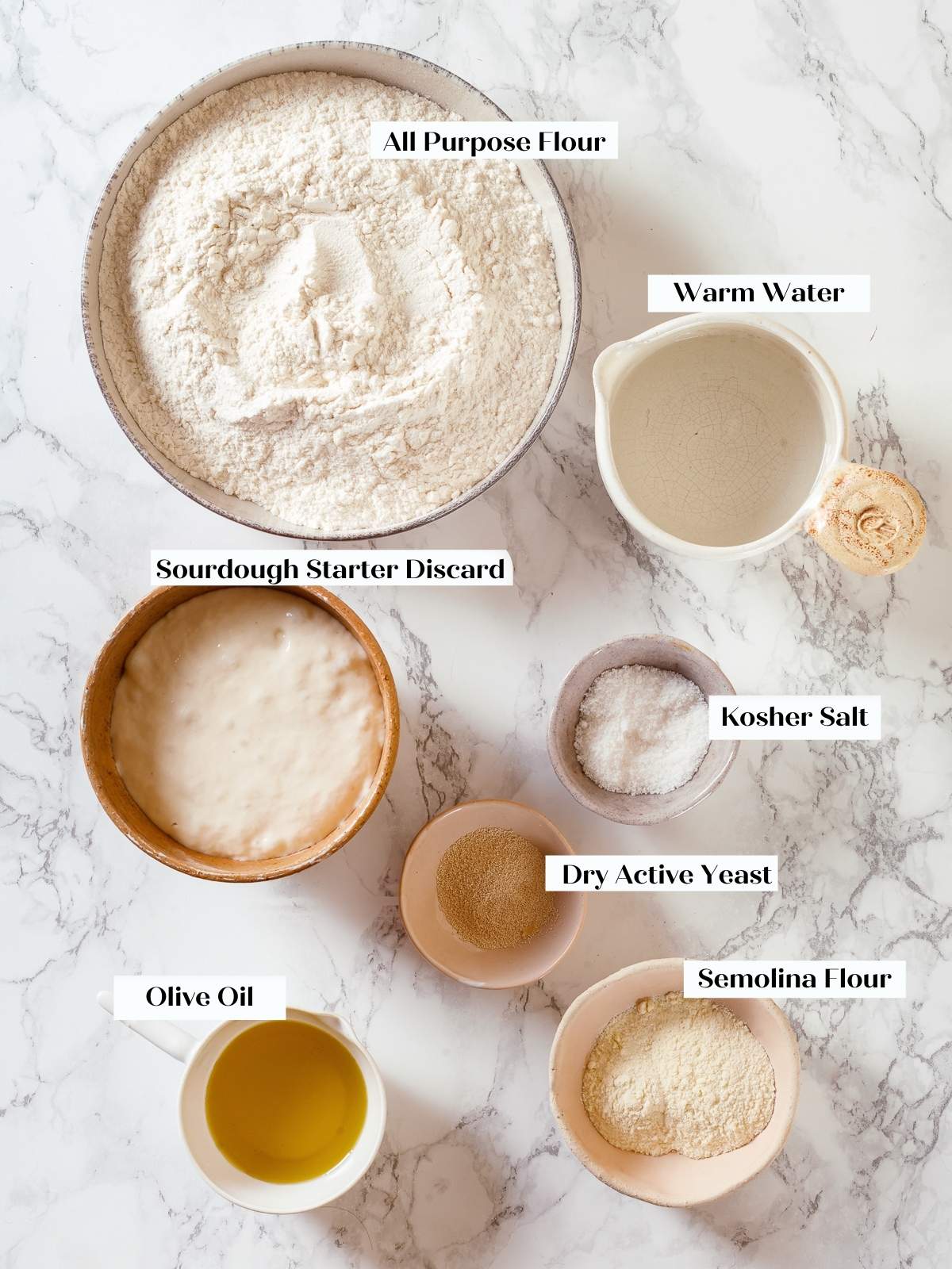 Ingredients for sourdough discard pizza dough measured and arranged neatly on a kitchen counter.