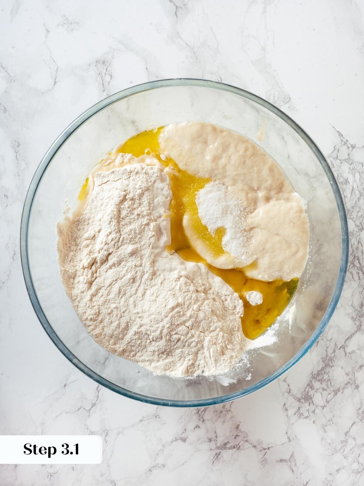 Mixing bowl with sourdough discard, flour, and yeast combined for homemade pizza dough.