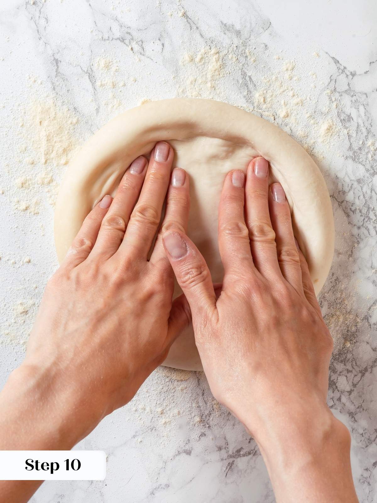 Shaped sourdough discard dough being stretched into pizza base for baking.