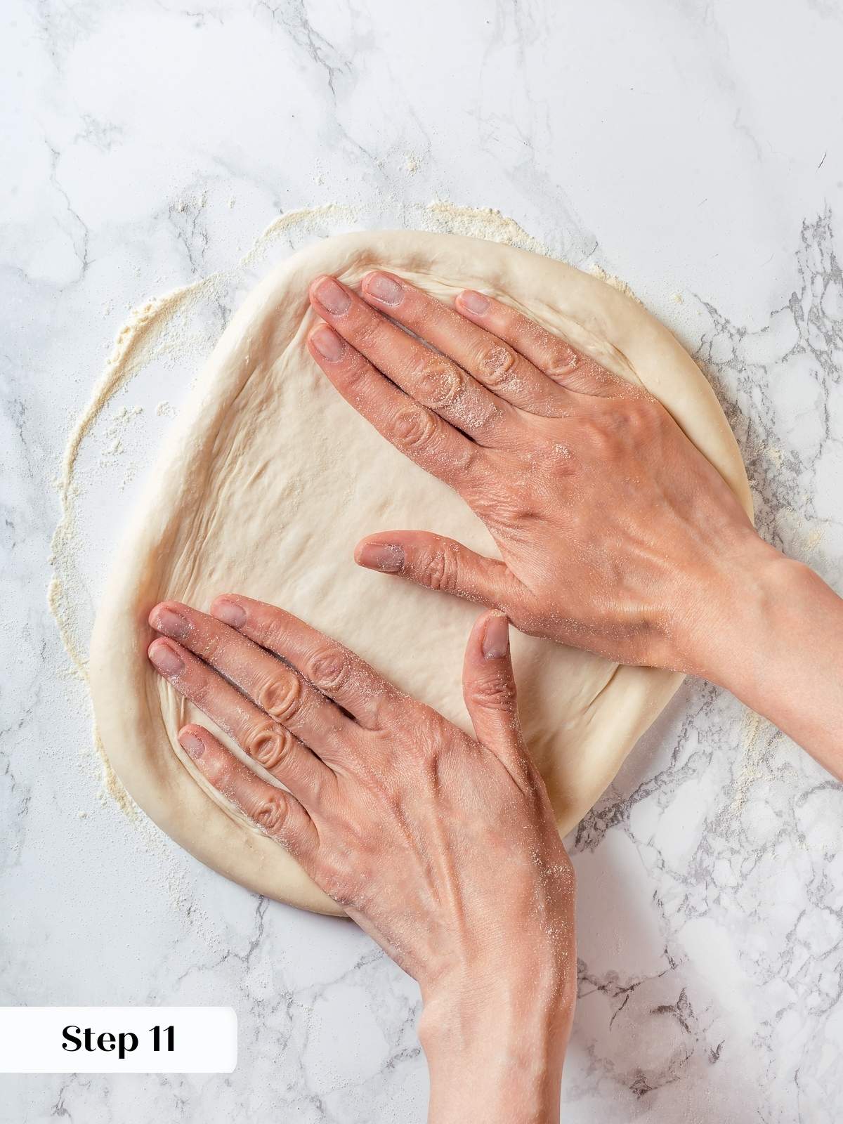 Hands gently stretching sourdough discard pizza dough to form thin crust before topping.