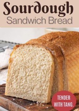 Homemade sourdough bread loaf sliced open on a wooden table, showing its soft crumb and tender texture.