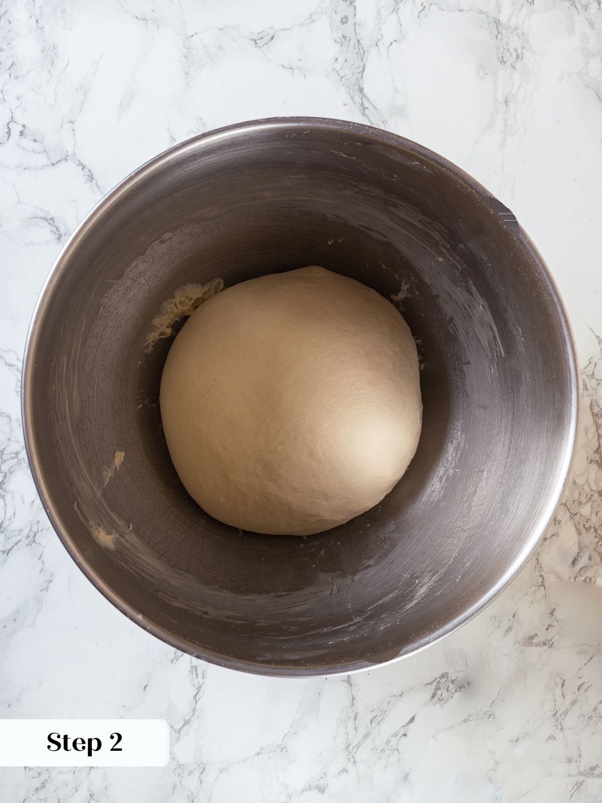 Elastic ball of sourdough dough resting after kneading, smooth and ready for first proof.
