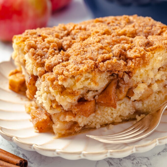Slice of cake showing apple filling baked between soft vanilla cake layers.