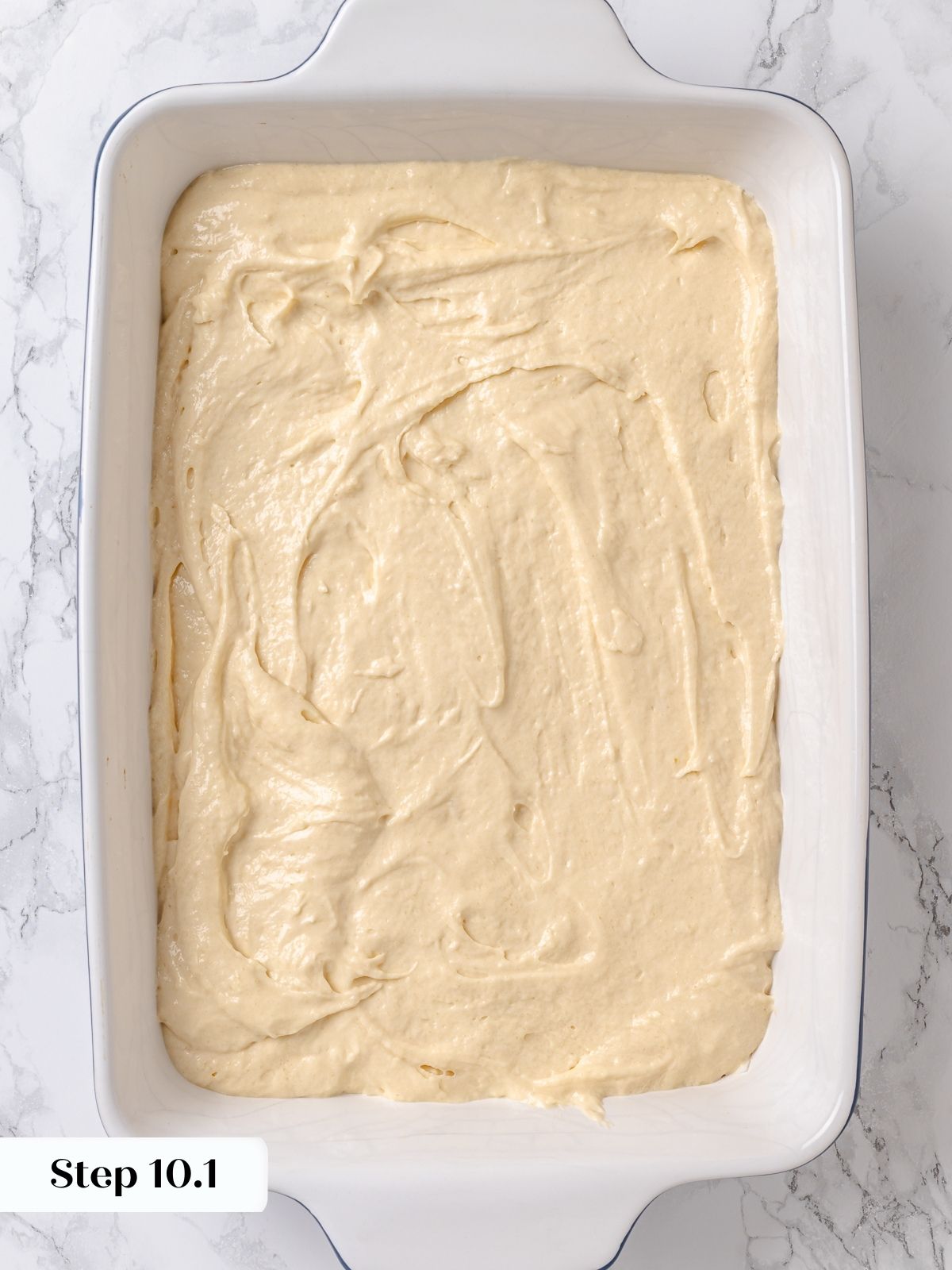 Batter spread into baking dish forming the first layer of apple coffee cake.