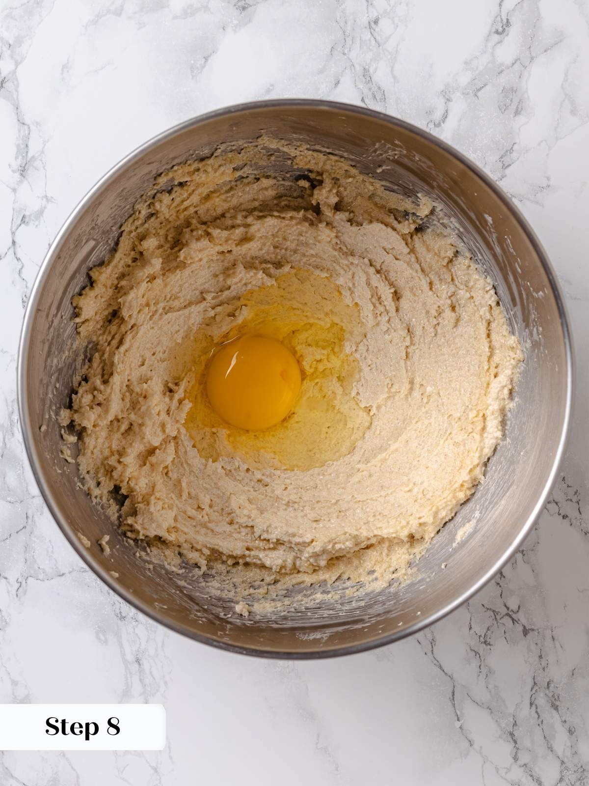 Eggs being beaten into butter and sugar mixture for apple coffee cake batter.