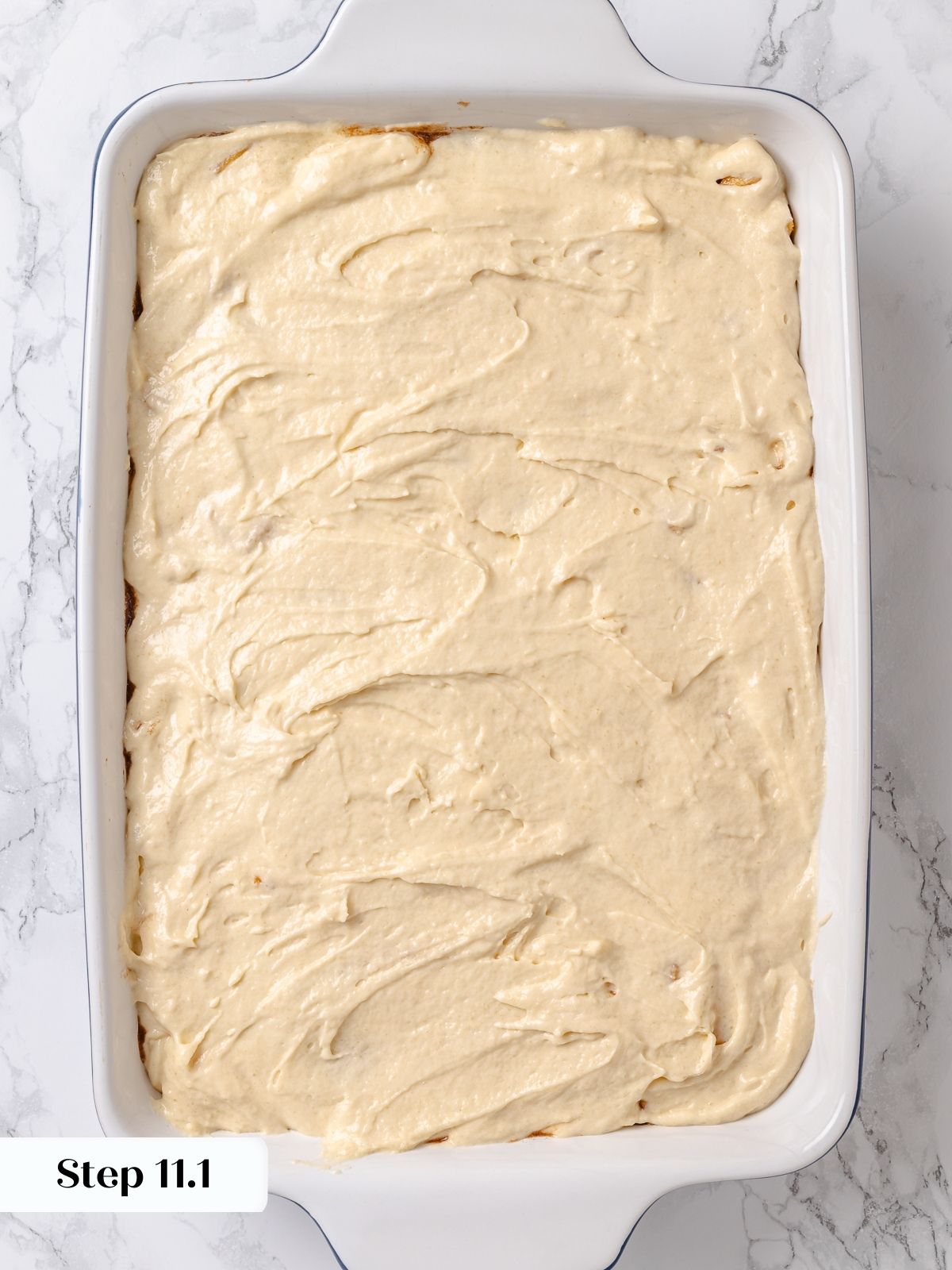 Batter spread over apples as final layer before adding crumb topping to cake.