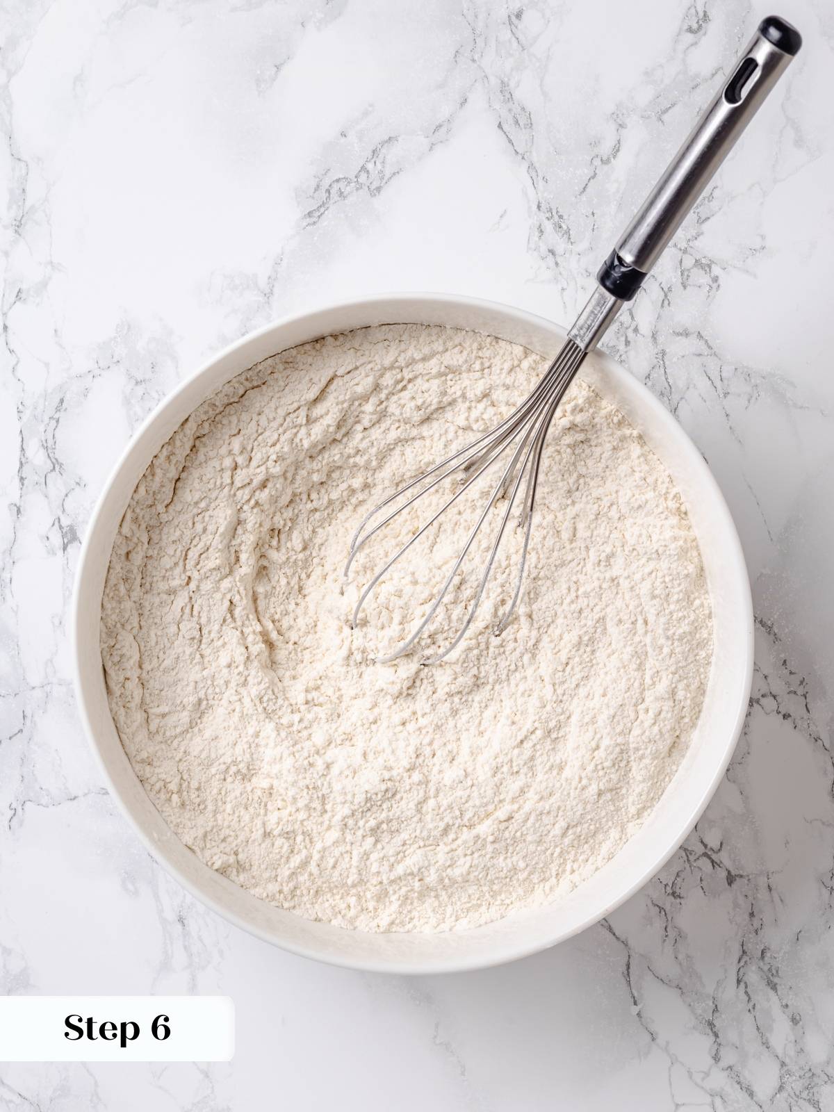 Whisked dry ingredients including flour, baking powder, and cinnamon ready for apple coffee cake.