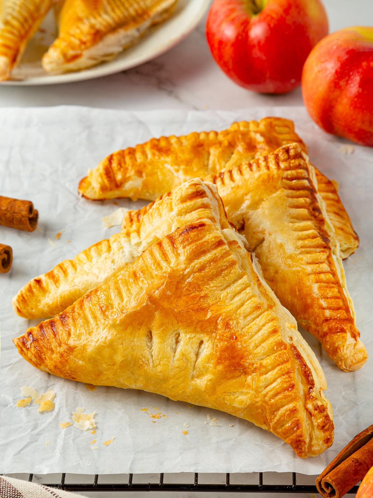 Freshly baked golden puff pastry turnovers cooling, with flaky layers and browned crusts.