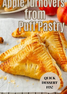 Golden puff pastry turnovers filled with warm cinnamon apples, cooling on a wire rack after baking.