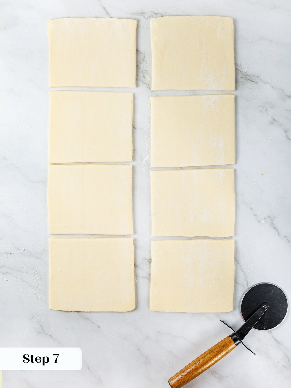 Puff pastry cut into even squares on floured surface, ready for apple filling.